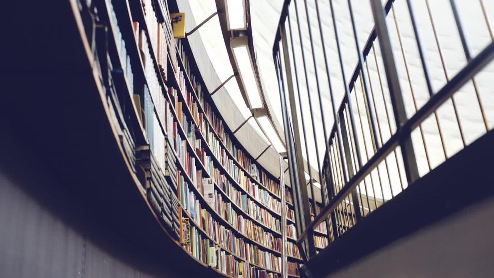 Prateleiras curvas de uma biblioteca cheia de livros