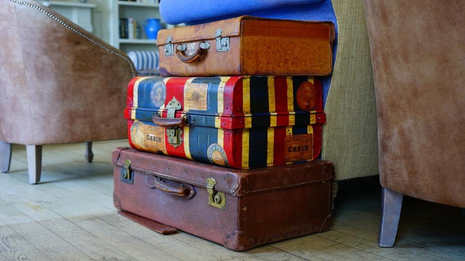 Malas de viagem antigas empilhadas em uma sala